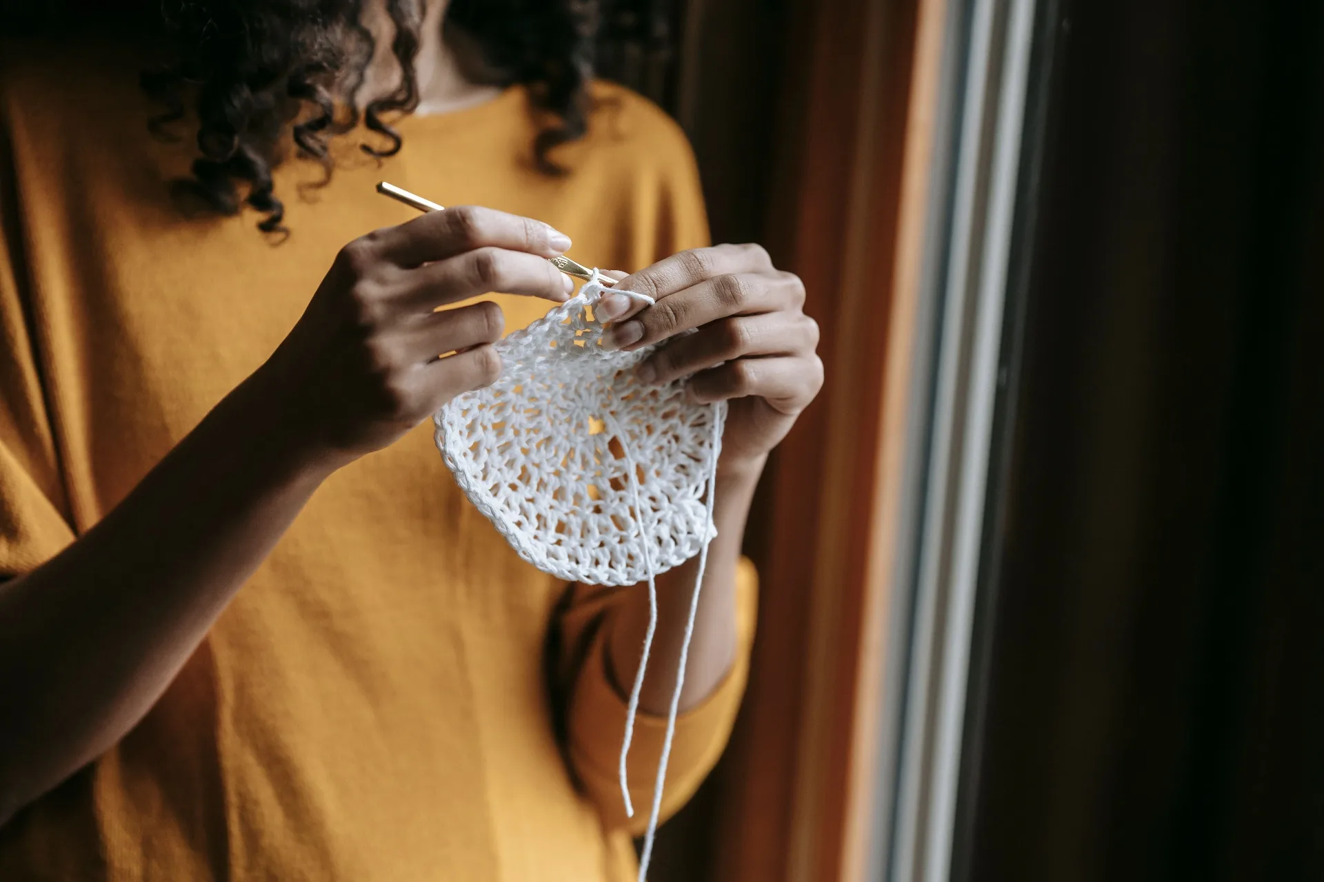 Hands crocheting a doily
